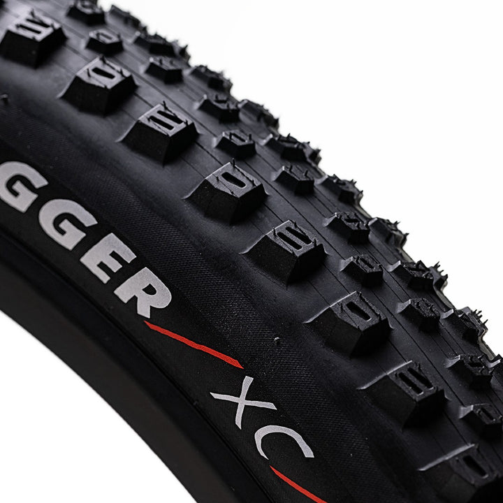 Close-up of a Kenda Dagger XC bicycle tire on a white background